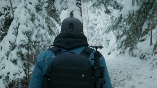 Fotograf mit Kamera spaziert durch den verschneiten Wald