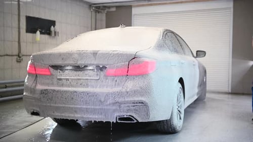 Man Washing Gray Car with White Foam