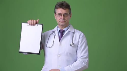 Mature Handsome Man Doctor Against Green Background