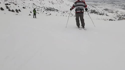 Person Skiing Down a Snowy Mountain Slope