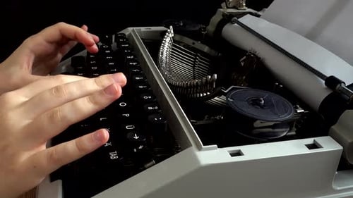 The girl is typing on a retro typewriter.