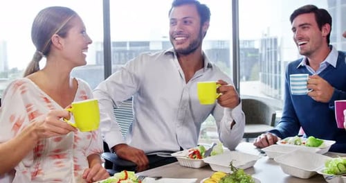Empresarios interactuando mientras desayunan