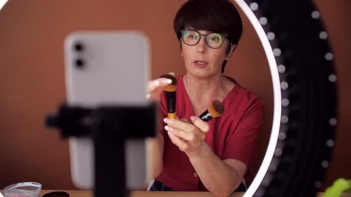 Atractiva bloguera envejecida hace reseñas de productos de belleza para un blog de vídeo da consejos a