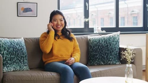 Cheerful Woman Talking on Phone Sitting on Sofa