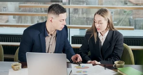 Man and a Woman Discussing Work in the Brightly Lit Modern Office. Concerned Male and Female Working