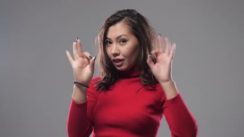 Smiling Woman Gesturing in Red Turtleneck
