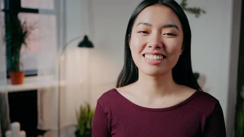 Close Up Portrait of Young Cute Asian Woman Smiling to Camera Posing at Home Interior Tracking Shot