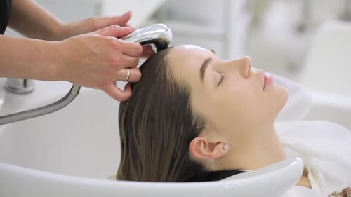 Beauty-Konzept, Junge Frau mit Friseur beim Waschen des Kopfes im Friseursalon