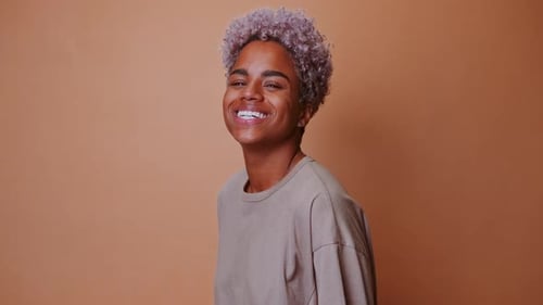 Smiling Young Adult Posing with Purple Curly Hair