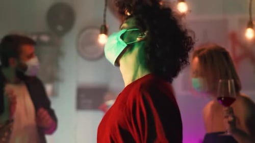 Masked Adults Dancing at an Indoor Gathering