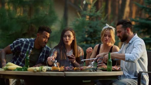 Cheerful Friends Relaxing on Grill Party in Forest