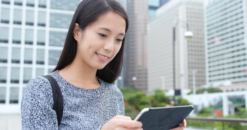 Woman use of tablet computer in city