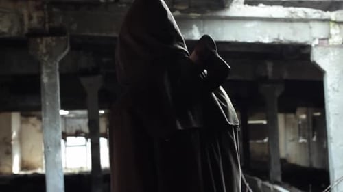 Hooded Figure with Axe in Dilapidated Building