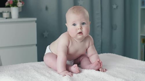 Adorable Baby Sitting on White Blanket in Nursery