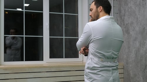Man in Lab Coat Thinking Indoors