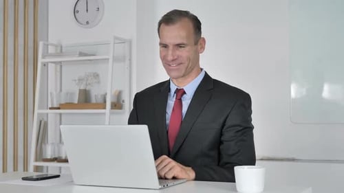 Man in Suit Waving During Video Call