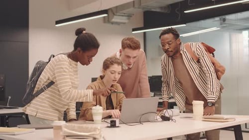 Team Collaborating on Laptop in Modern Office