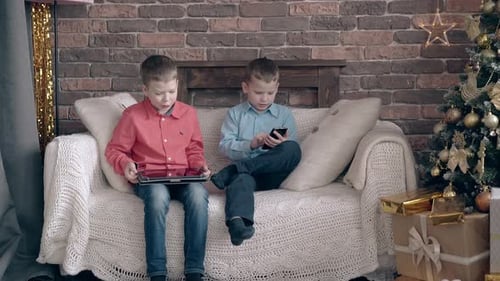 Boys Using Technology on Couch During Christmas