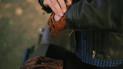 Unrecognizable Motorcyclist Coming Up to His Motorcycle Taking Brown Leather Gloves and Wearing