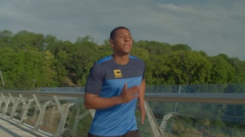 Portrait of Muscular Build Sporty African Man Running in City at Sunrise