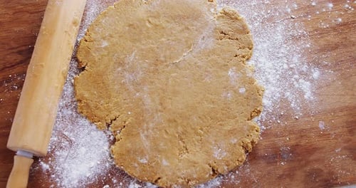 Flat Cookie Dough and Rolling Pin on Wood