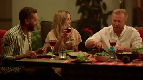 Friends Enjoying Meal Together Outdoors at Night