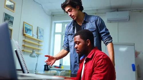 Two Colleagues Collaborating on a Laptop in Office