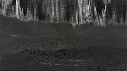 Aerial View. Black Sand Beach. Beautiful Ocean Waves Crashing on Coastline.