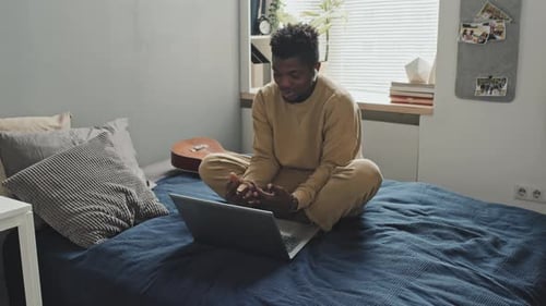 Young Adult Works on Laptop at Home