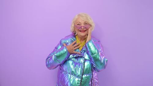 Excited Elderly Woman in Iridescent Jacket