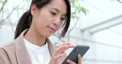 Woman using mobile phone in city at outdoor