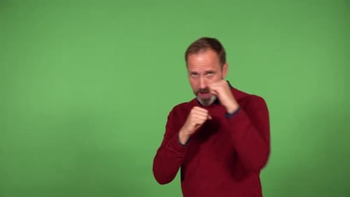 A Middleaged Handsome Caucasian Man Boxes the Camera Green Screen Background