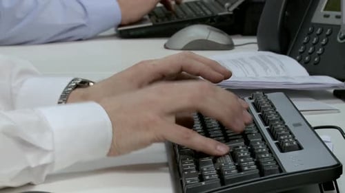 Two businessmen using computer keyboards