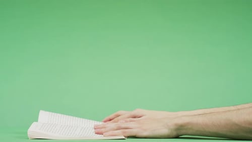 Hands Turning Pages of a Book on Green Screen