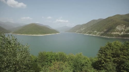 A Large Mountain Lake with Turquoise or Blue Water, Green Mountains and Hills