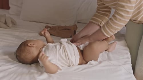 Padre que le pone un pañal al niño