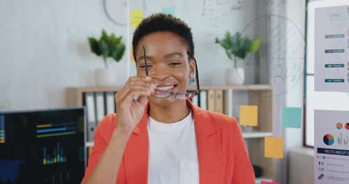 Smiling Woman in Office Environment with Charts