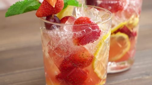 Refreshing Fruity Drink Poured Over Ice on Table