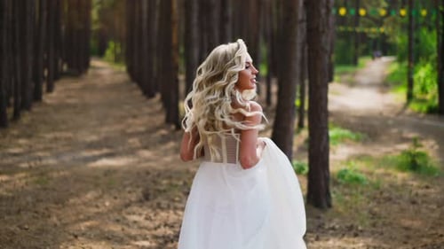 Pretty Woman in Elegant Wedding Dress Runs Along Park