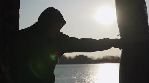 Hooded Boxer Training at Sunrise Near the Water