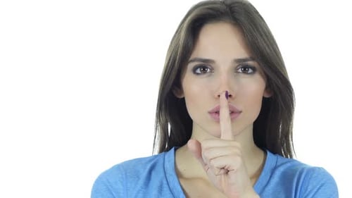 Woman Making Shushing Gesture Against White Background