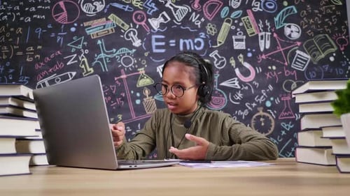 Asiatisches Mädchen erklärt und nimmt Videoanrufe auf einem Laptop mit drahtlosem Mikrofon zu Hause entgegen