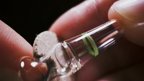 Close-up of Medical Ampule being held by Fingers