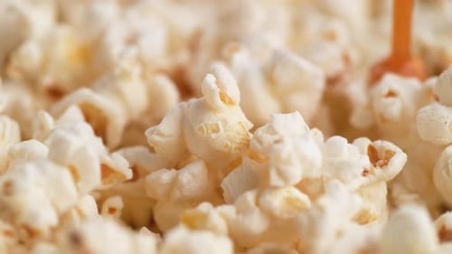 Caramel Drizzled Over Fresh Popcorn in Close Up