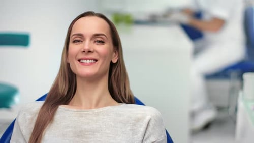 Smiling Woman Patient in Modern Dentist Office