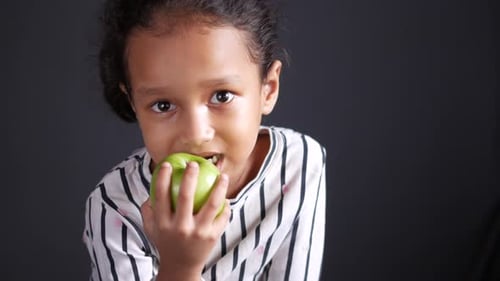 Child Girl Eating Apple While Sited