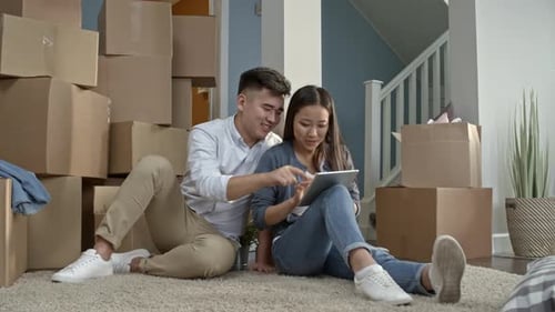 Young Couple Using Tablet in New Home