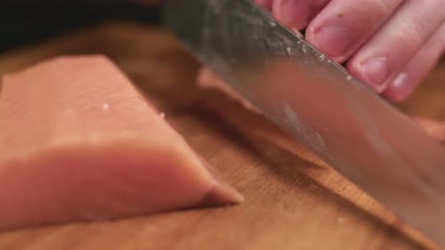 Sushi Man Cuts Salmon Fillets on Wooden Board