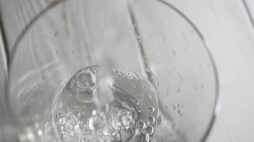 Nahaufnahme von Wasser, das in ein transparentes Glas fließt