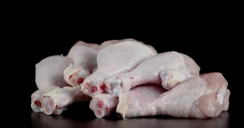 Raw Chicken Drumsticks on a Dark Background